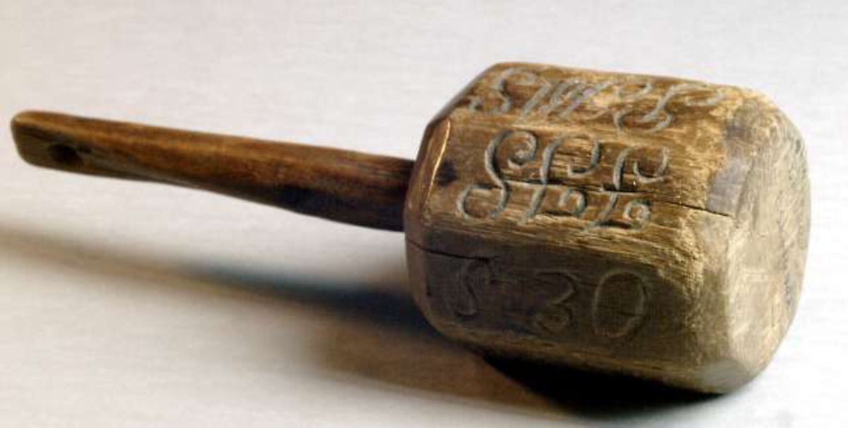 Tiggarklubba av trä. Åttkantig, med hålförsett skaft. På klubbans sidor inristat initialer samt: År 1812 Tige Klub.
