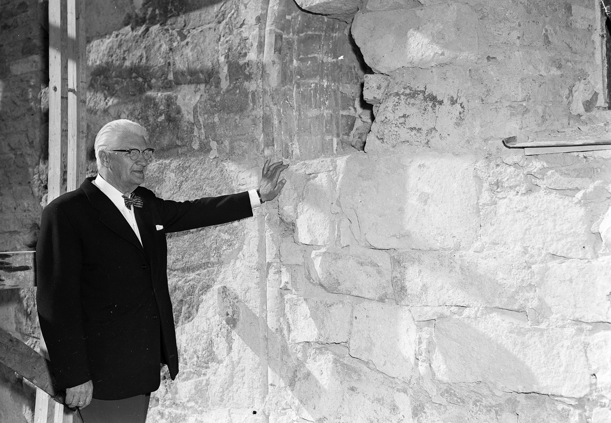 Kyrkoherde Gösta Westberg "vid den återfunna ärkedjäknens värdighetsportal i Bälinge kyrka", Bälinge, Uppland juli 1956