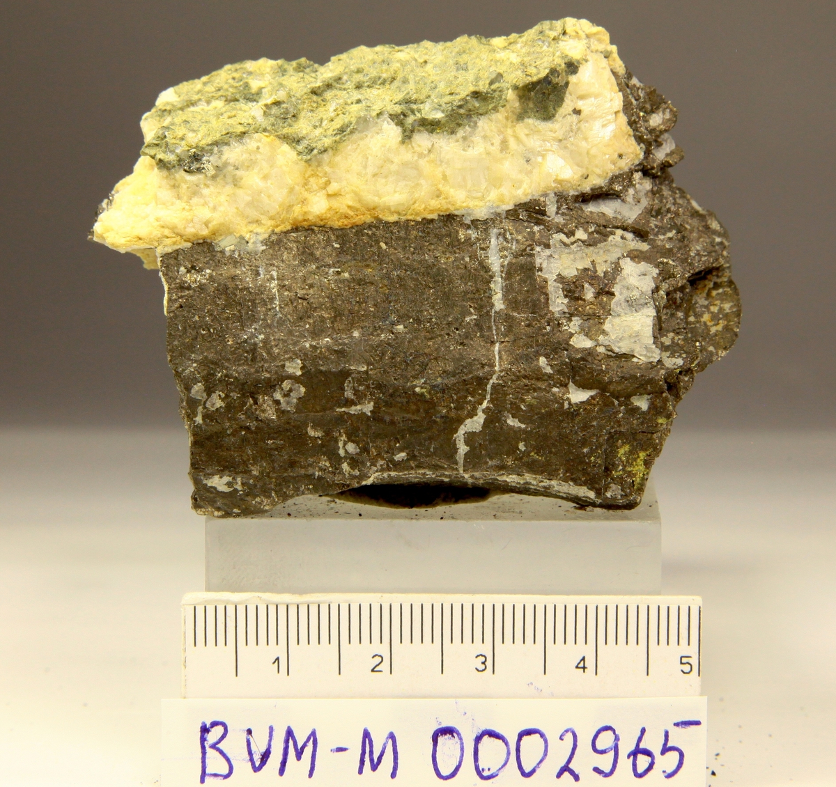 Grovkornet pyrrhotitt, mulig 2 krystallflater, med hvit karbonat.
Mannsfjellstunnelen, E39, Skaun.