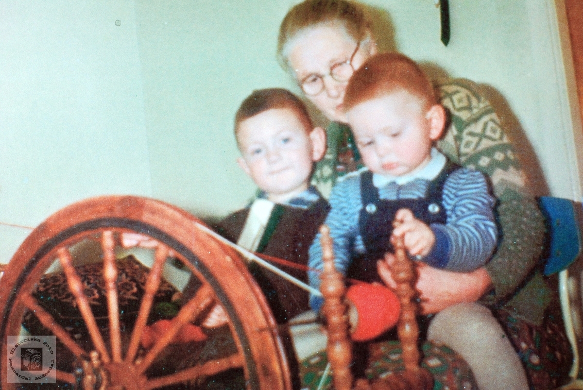 Bestemor, Martine Strædet, ved rokken med barnebarna. Audnedal.