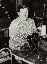 Fru Aase frå konfeksjonsfabrikken sitter ved en symaskin