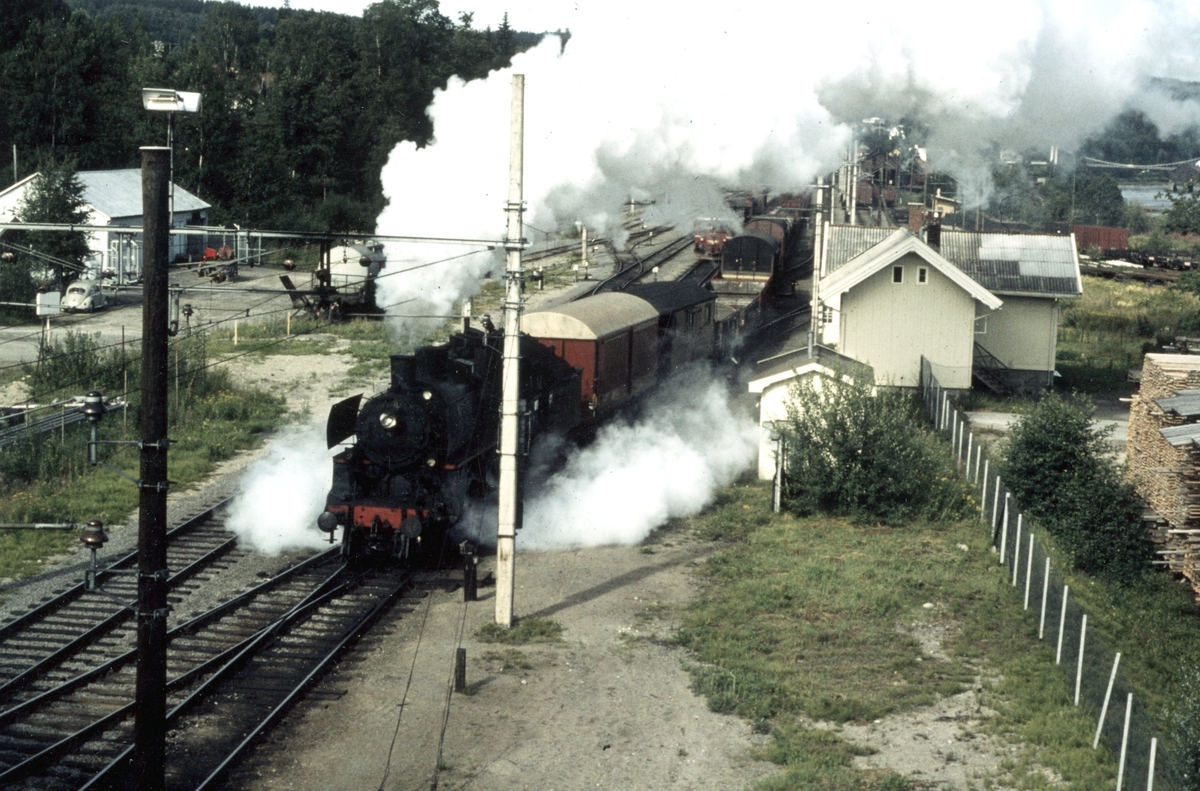 Damplokomotiv type 26c nr. 411 med godstog til Elverum kjører ut fra Kongsvinger stasjon