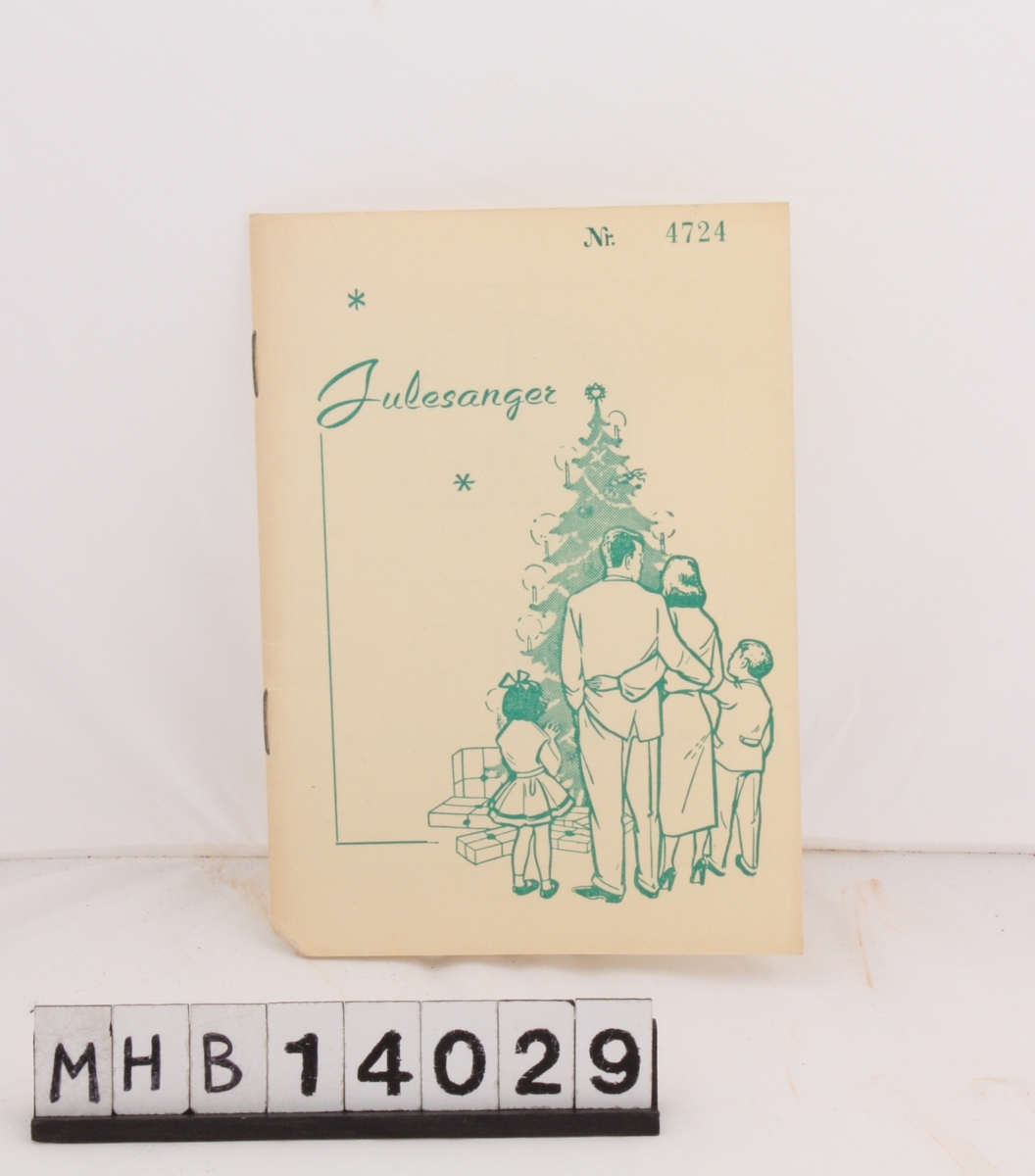 Rektangulært hefte med julesanger. På fortiden er et motiv som viser en familie ved et pyntet juletre med gaver under. Foruten sangtekster inneholder heftet en rekke lokale bedriftslogoer.