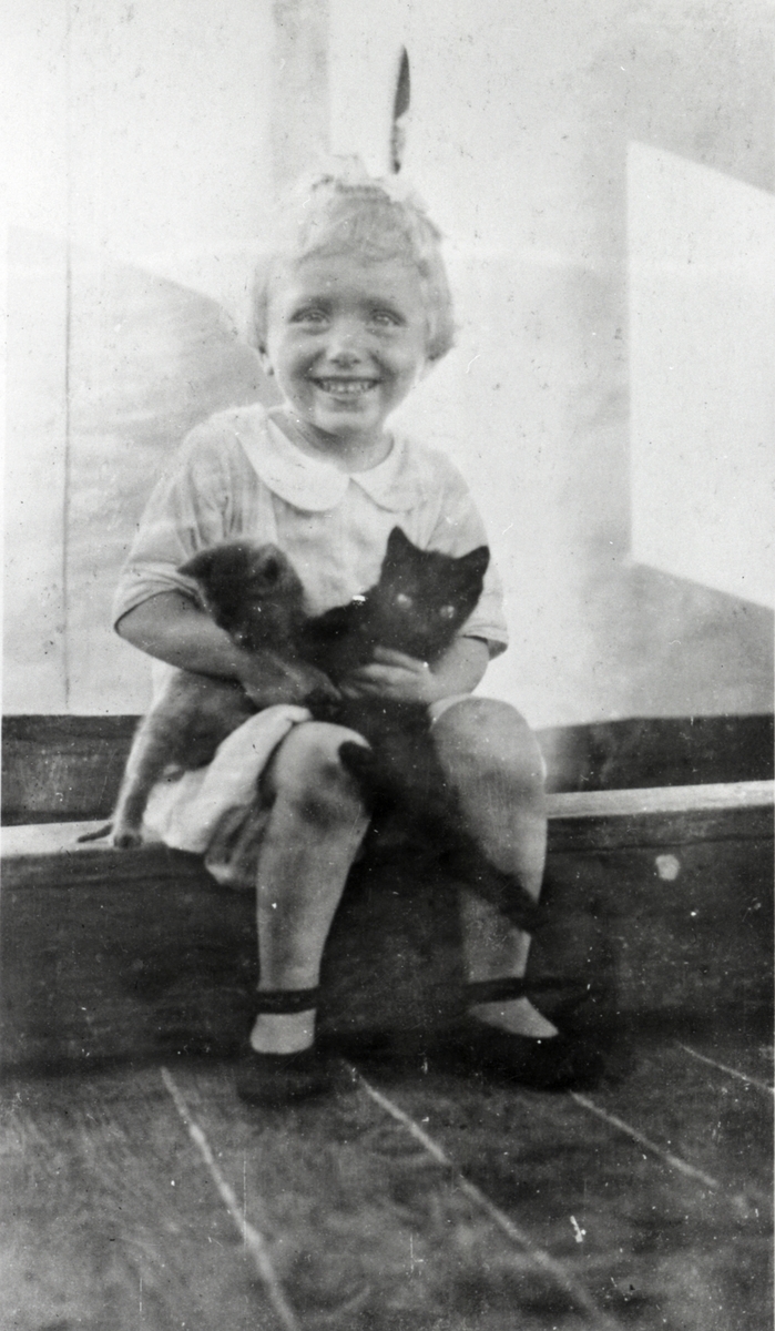Jente med to katter. Inger Lütken, datter av skipsfører Thor Kristian Lütken, ombord i D/S 'Brighton' (b.1902)