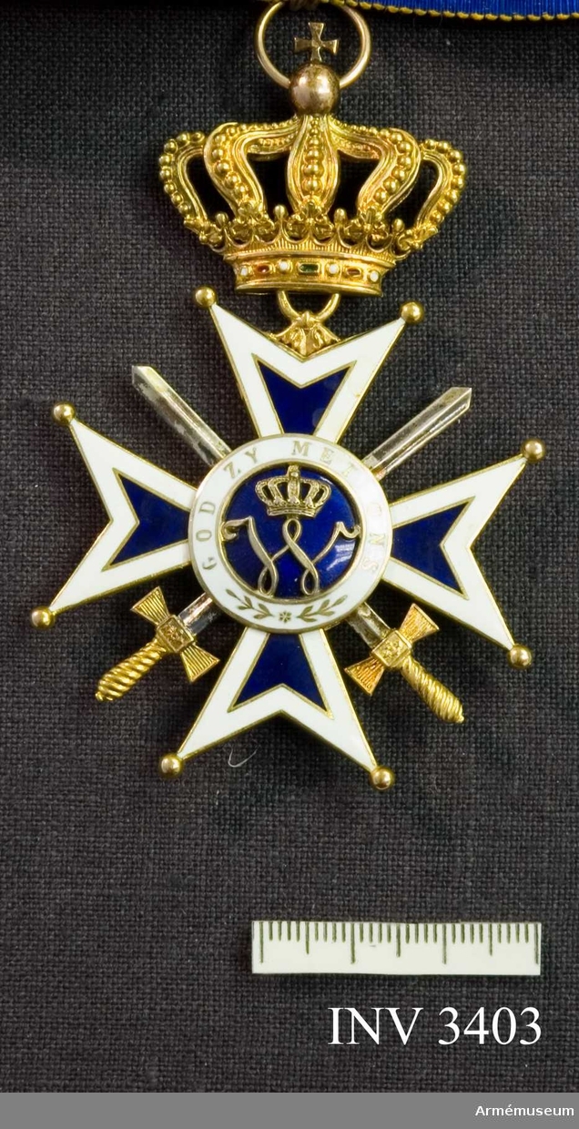 Kommendörstecknet av Nederländska Oranien-Nassau orden m svärd.
Mått: 55 mm. Gott skick. I guld och vit och blå emalj. Ordenskorset är ett Georgskors med guldpärlor på spetsarna, ytterkanter av vit emalj och det inre i blå emalj. Två korslagda svärd vilar mellan från och  åtsidan, dessa är i guld. I mitten en blåemaljerad rundel med ett W, krönt med kunglig krona, i mitten, utfört i guld.  Detta är Wilhelminas monogram. (1880-1962). Abdikerade 1948. Runt rundelen ett vitt smaljerat band med i guldskrift: GOD ZY MET ONS (Gud är med oss). Frånsidan är utformad på samma  sätt, men i mitten på blåemaljerad botten syns i guld ett  svärdsvingande lejon. Orden hänger i en kunglig krona utförd i guld med runt brämet ädla stenar. Orden hänger i ett gult band  av vattrat siden, med vit och blå kant. Bandet skall knäppas  runt halsen. På det vita fältet runt lejonet står det: JE  MAINTIENEDRAI (jag vill hålla ut).