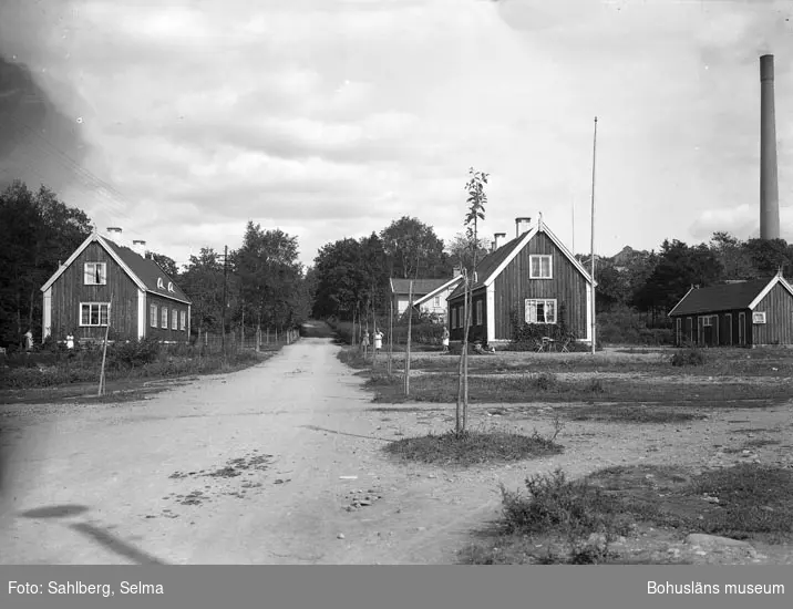 Text som medföljde bilden: "Bruksgatan Munkedal. Huset till vänster rödmålat, där bodde lokförare Lindqvist. Huset till höger brunmålat där bodde bl.a på 50-talet Albert Wallin. Bakom det bruna huset lokförare Dahlqvists hus som var privat. De bägge lika byggda av MAB som tjänstebost."