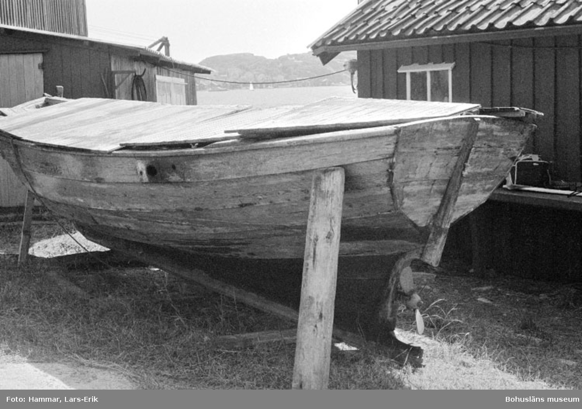 Motivbeskrivning: "F.d varv i Skredsvik "bohusjulle (se Bb 17: 21). I bakgrunden till höger båtbyggarverkstaden, till vänster tillbyggnaden till virkesmagasin."
Datum: 19800717
Riktning: S