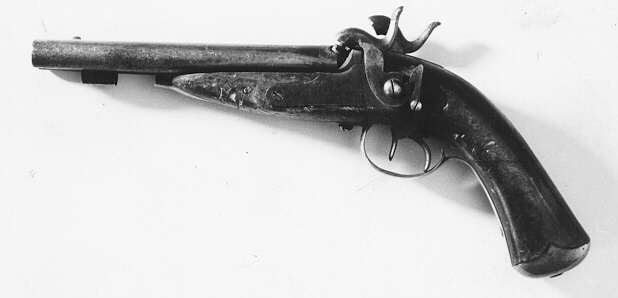 Slaglåspistol, dubbelpipig kal. 14, av
KungligaGeneralpoststyrelsens modell från år 1853 (skr. 18540323).
Pistolenhar dubbla pipor hopfogade med en spång på översidan.
Pipornas längd190 mm. Svansskruvar med krok och separat svansjärn.
Låsblecken heltinställda i stocken, försedda med varhackar. Endast en
låsskruv somgår från vänster låsbleck. Halvstock av björk med
mässingbeslag.Kolvkappan med två spetsiga flikar. Laddstock av trä
med hornända.Bräcka i kolv. Vänster hanskruv och laddstock saknas.