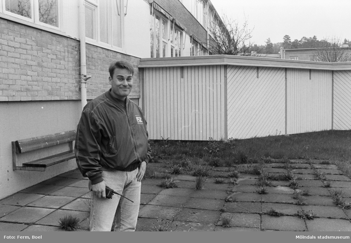 Dokumentation av Sagåsens flyktingförläggning 1992. En man står utomhus framför en byggnad. En bänk och insynsskydd finns i bakgrunden.