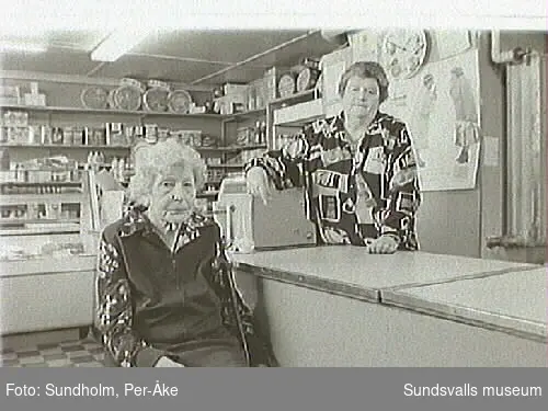 Fotodokumentation av Märta Persson, livsmedelsaffär i kv Mandeln 1, Majorsgatan 17, Sundsvall.1 juli 1922 övertog Märta Persson (gift Claésson) mjölk- och speceriaffären. Affärsnamnet blev hennes flicknamn. Fram till 1980-talets mitt arbetade hon dagligen i affären. Den förestås nu av dottern, Kerstin Sunding.