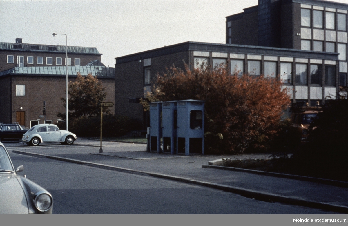 Vy från Knarrhögsgatan mot Folkets hus samt Stadshuset i Mölndal, 1970-tal. Till höger ses tre cyanfärgade telefonkiosker på trottoaren.