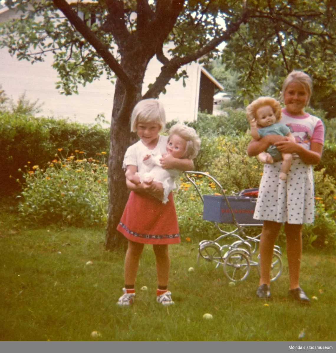 Christine med sin syster Ingela i mormor och morfars trädgård på Kryssgatan i Mölndal, augusti 1976.