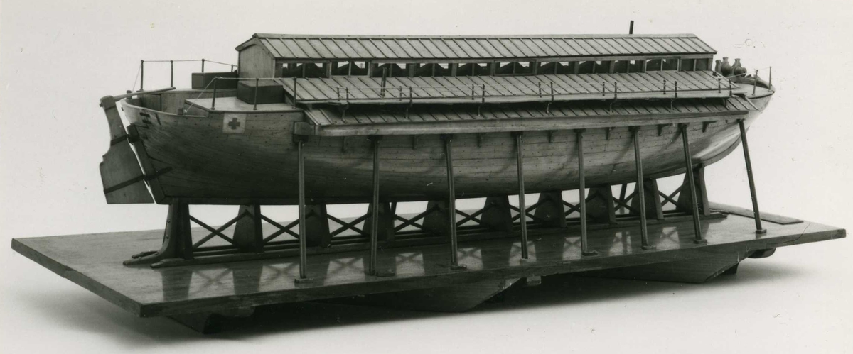 Kravellbyggd modell av sjuktransportfartyget Widar/Vidar.
Modellen står på stapelblock och är stöttad av åtta stöttor på vardera sida. Stapelblocken är fastsatta på en bottenplatta av mahogny försedd med skala.