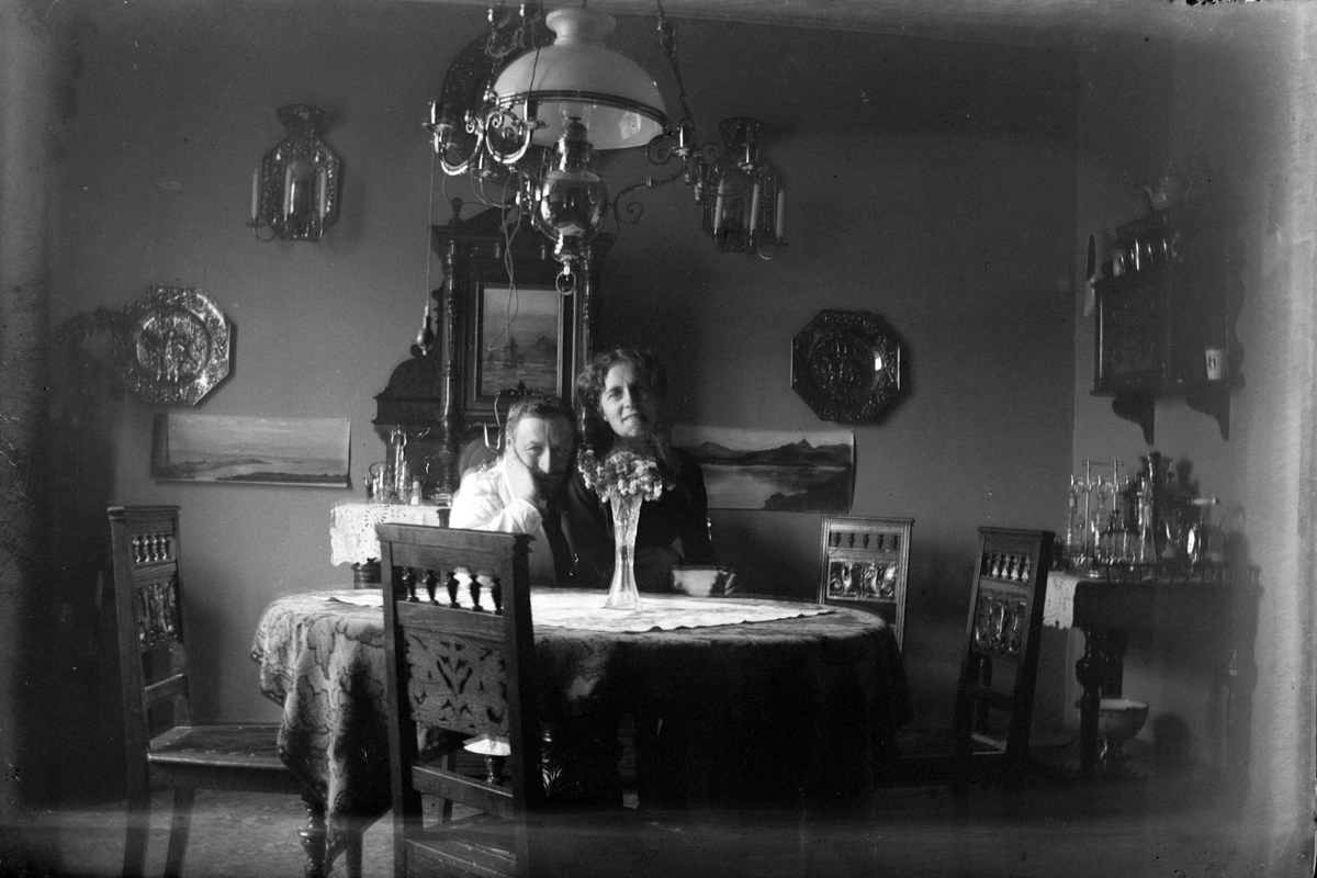 Lege Christian F. Rossow og kona Dagny ved rundt bord i pent møblert stue.