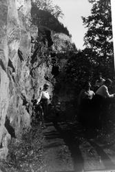 Fire personer med sykler, fotografert med en fjellvegg til v