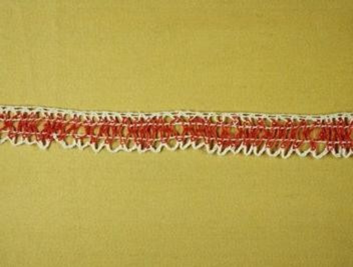 Teknik: Spetsen består av en nålrad mot tyget, ett mellanparti med röda snodder och en vit flätning som udd.
 

Denna spets tillhör ryska samlingen