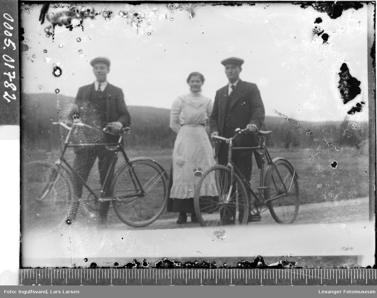 Portrett av to menn med sykler og en kvinne.
