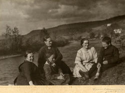 Gruppe utendørs, ved en elv. Tre kvinner, en jente og en gut