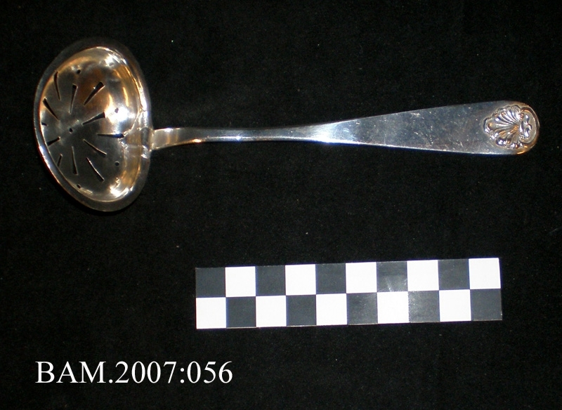 Sukkerskje med støpt skjelldekor. Fremstilt av en gullsmed "I. O." ca 1860-70.