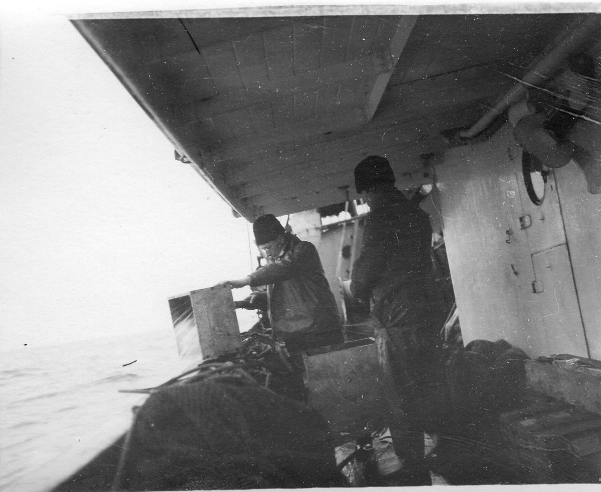'Skagerrakexpeditionen 1933-03-06 - 1933-03-08: ::  :: 2 st män på båtens däck, Sune Swärd och Paul Henrici sållar (och fryser). ::  :: Ingår i serie med fotonr. 2828-2838.'