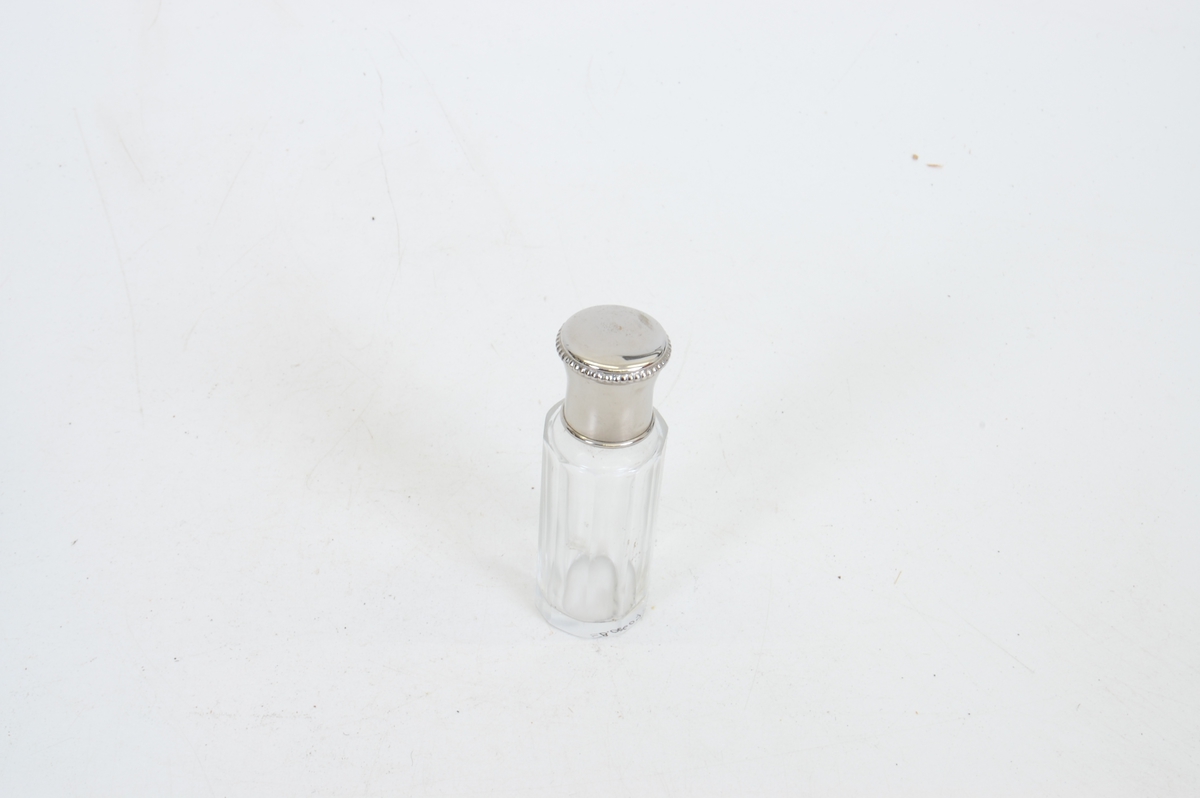 Form: rektangulær veske/koffert (smykkeskrinfasong) med mange små flasker og skrin samt en kles-/skobørste
