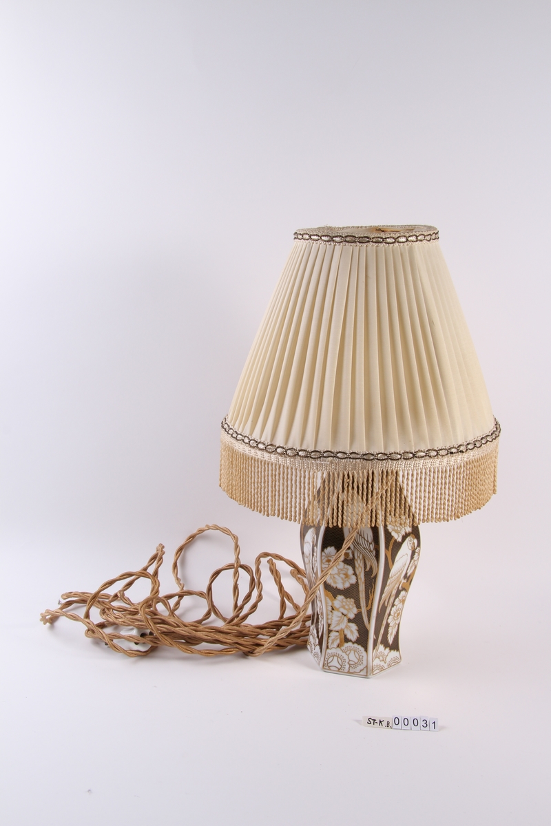 Elektrisk lampe med vaseformet lampefot og rund lampeskjerm.