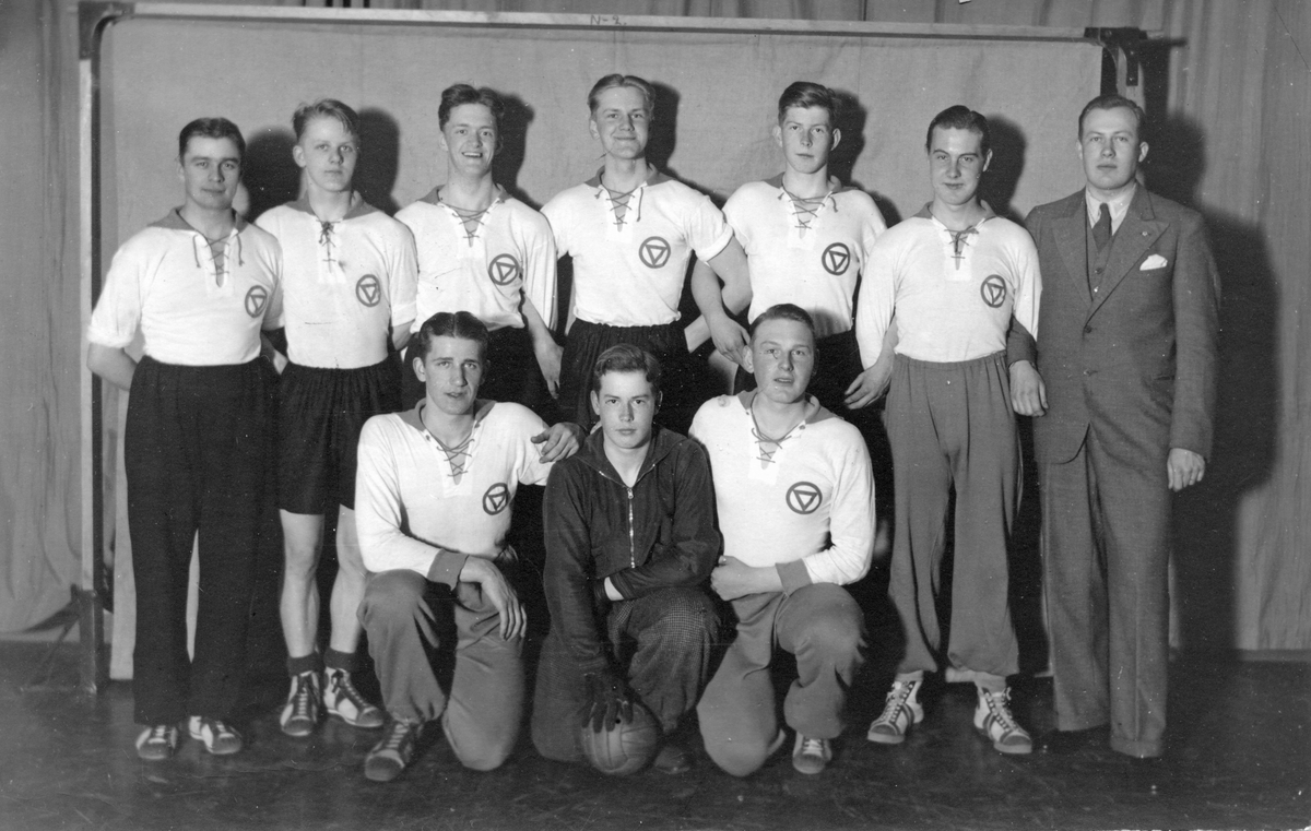 Första KFUM-laget i handboll, i Köping 1936. Stående från vänster: Arne Eriksson, Nils "Linkan" Lundgren, Ingemar Sandberg, Sven Skoglund, Olle Rydberg, Börje Eriksson och K. G. Andersson lagledare. Fotograf okänd.