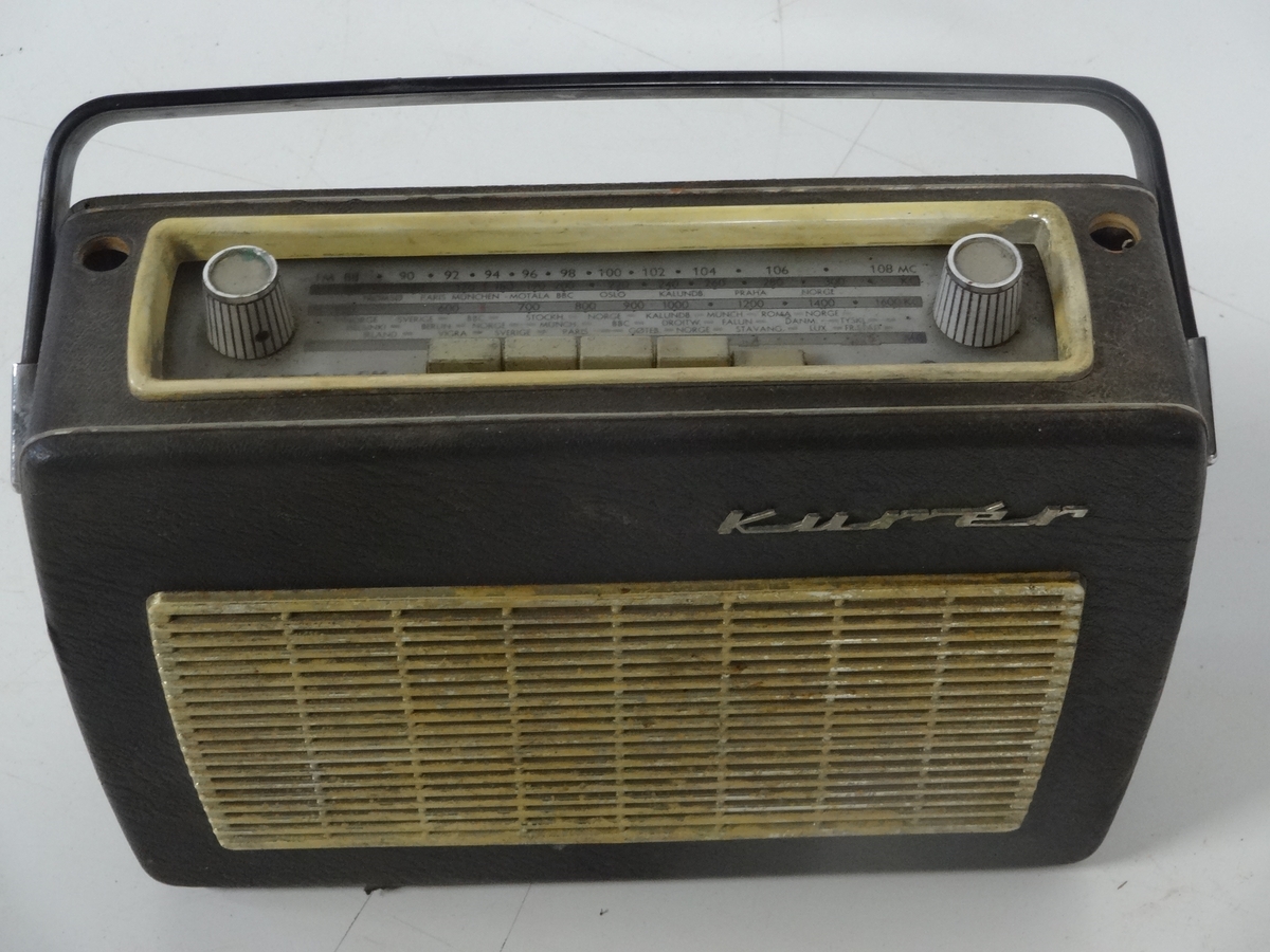 Transistorradioapparat fra Radionette av type Kurér med tilleggsbetegnelsen "Marine deluxe". 

Radioen har merker på undersiden som forteller at den kostet 590 kr og hade en stempelavgift på 47,50 kr. Apparatet fungerer ikke.  Det er og mulig å koble til båndspiller / grammofon.

Batteri er borte.