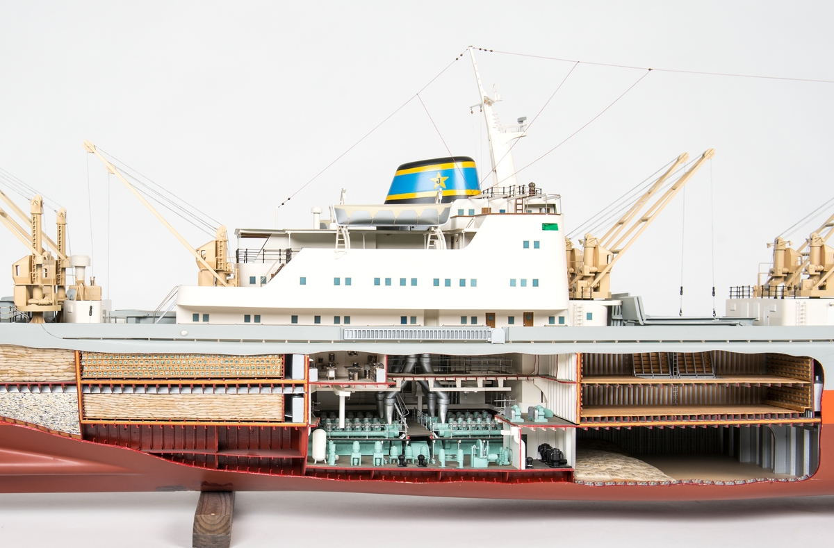 Modell av lastmotorfartyget Rio de Janeiro, gjord i block (trä). SB sidan uppskuren, visande lastrum  4, 5  och maskinrum.  I lastrummen styckegodslast. Lucka 4 och 6  öppna.