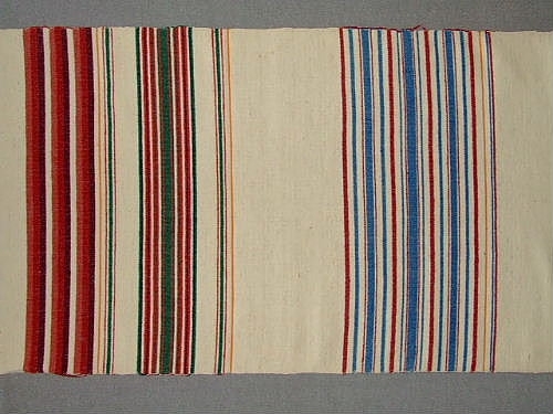 Bolstervarsprov i olika randningar och olika färgställningar. Varp i bomull och inslag i ullgarn, med undantag av en bit där även inslaget är i bomull. Vävdes för en inventering på 1940-talet.