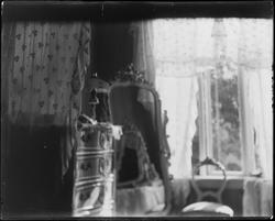 Interiør med stilmøbler samt åpent vindu i bakgrunnen.