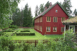 Åsetbygningen fra 1795 regnes som områdets første våningshus i to etasje. Huset er rødmalt med gule vinduskarmer. For å oppnå symmetri er noen vinuer falske, de er malt på veggen.