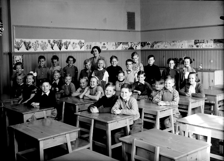 Almby Norra skola, klassrumsinteriör, 26 skolbarn med lärarinna fröken Märta Larsson.
Klass 2aq, sal 1.