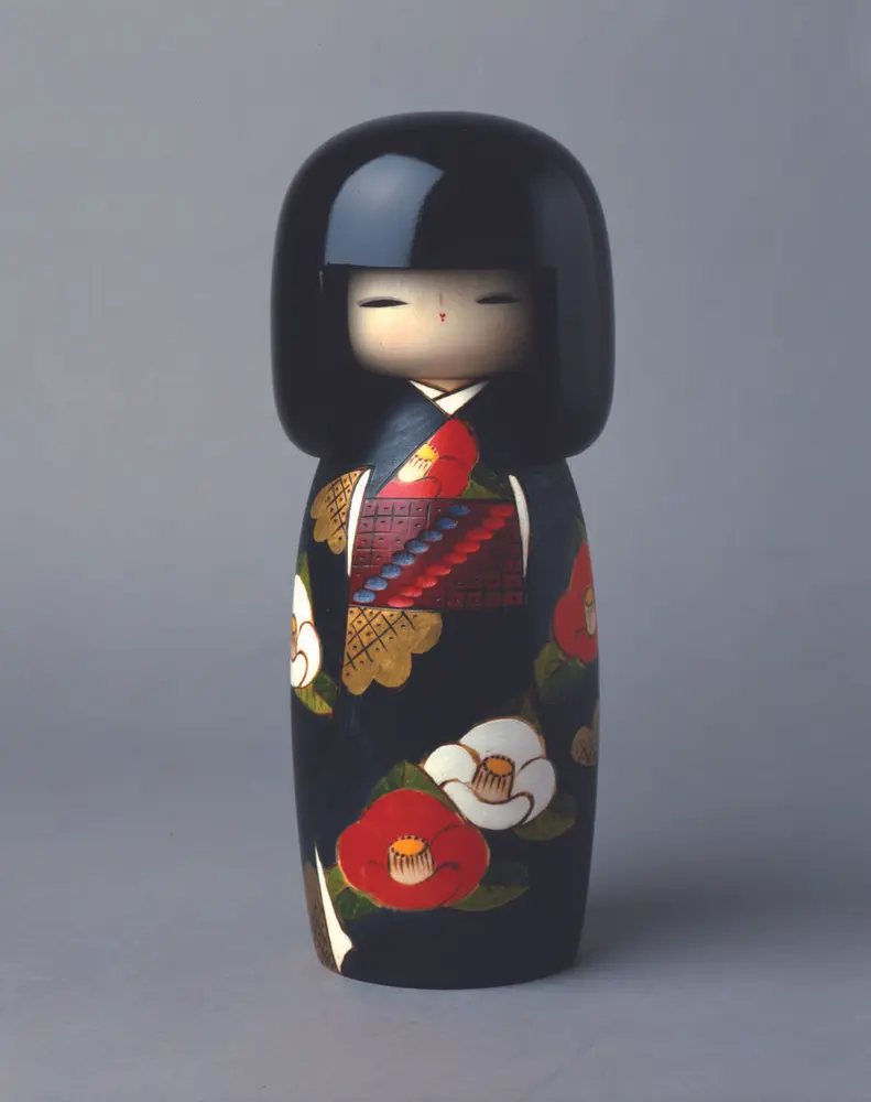 Japansk kokeshi-dukke. Tredukke malt med kamelia-blomster