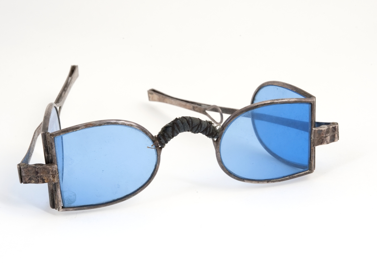 Et par solbriller med blått glass. og grønt futteral, ikke av skinn.