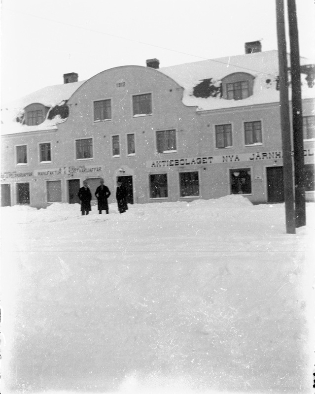 "Järnhandelshuset" i Norberg.
Givaren föddes i lägenheten längst upp till vänster den 9/4 1914.
"Till vänster ses Edlunds manufakturaffär, därefter en hattaffär och så järnhandeln. Bilden är troligen tagen ca 1918. Okända personer står framför huset. "Järnhandlaren" Ringlund bodde på första våningen till höger i huset och Edlund bodde på andra sidan av huset. Överst var ett par enkelrum och två lägenheter på 3-4 rum vardera. Vi som bodde i huset umgicks i synnerhet på jularna då vi hade julgransplundringar i alla lägenheterna."
Ringlund kom till Norberg och öppnade järnhandel i Abrahamsgården. Han lät sedan bygga "Järnhandlarhuset". Hans son  Josef Ringlund tog sedan över.