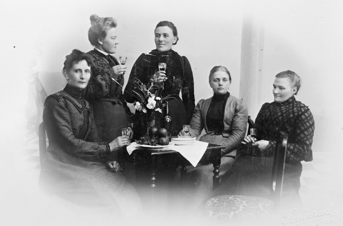 5 damer i studio med glass i hendene. Pyntet bord. 
Fra venstre: Borghild Solberg, Karen Bjerke, Kristiane Bye, Hanna Ausdal og Oline Stenersen.