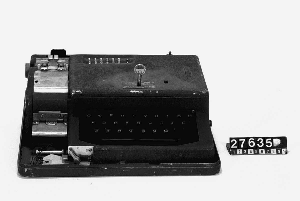 Mekanisk krypteringsmaskin med tangentbord och sex inställningshjul. Med skrivare för två pappersremsor, en kodad och en i klarskrift. Elektrisk drift, Nyckel till huven separat.