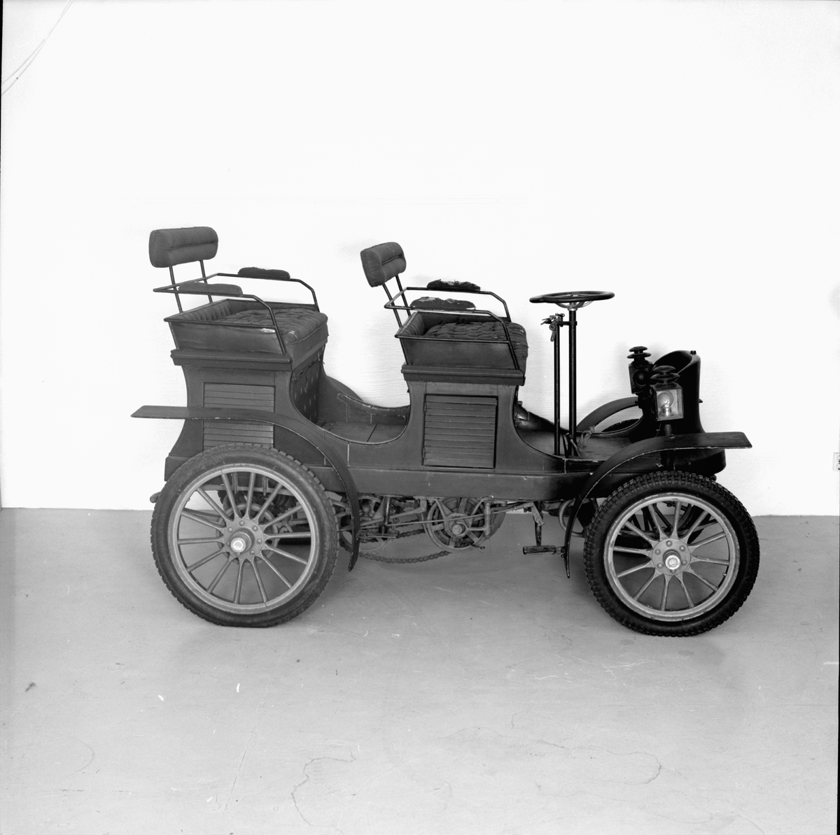 Scania 1902 för fyra personer. Motorn är tillverkad av Aster, Atéliers de Construction Mécanique l'Aster, Frankrike. Kedjedrivning till bakaxeln av de Diontyp. En Kemper motor med tvångsstyrd avlopps- och självstyrd inloppsventil. Karossen byggdes av G A Jönssons Vagnfabrik AB i Malmö och tyg till dynor och ryggstöd samt de ursprungliga lyktorna var inköpta hos firma Sally Mayjer i Köpenhamn.  Encylindrig vattenkyld fyrtaktsmotor. Planväxellåda med två växlar framåt samt backväxel.
Hastighetsutväxlingar 2, kraftöverföringen vid de olika växlarna sker medelst kedjor samt till bakaxeln med en enkel kedja i mitten av vagnen. Bakaxel differentialen är upphängd i vagnen och sker kraftöverföringen till bakhjulen medelst kardanaxlar med dubbla knutar.