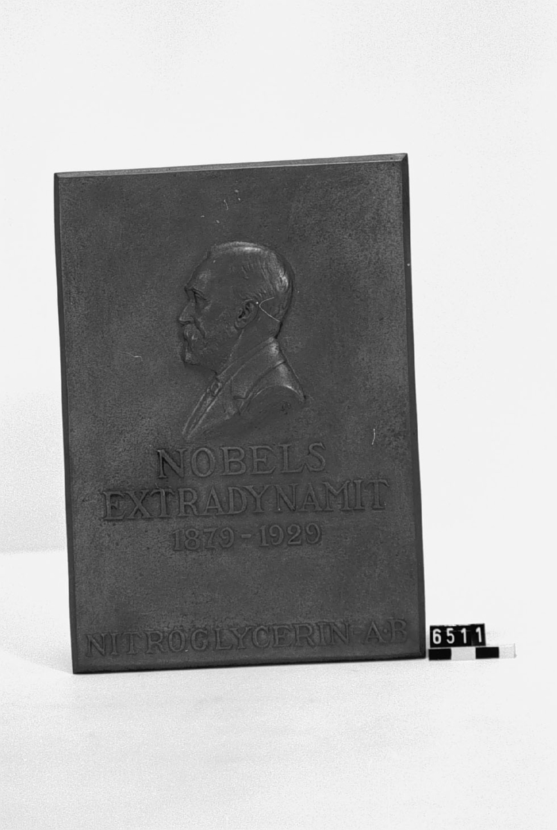 Medaljong, över Alfred Nobel gjuten i koppar till minne av Nobels Extradynamits 50-årsdag. Med porträtt i relief av Alfred Nobel. Tillverkad 1929 för givaren. Text: NOBELS# EXTRADYNAMIT# 1879-1929# NITROGLYCERIN A.-B.".