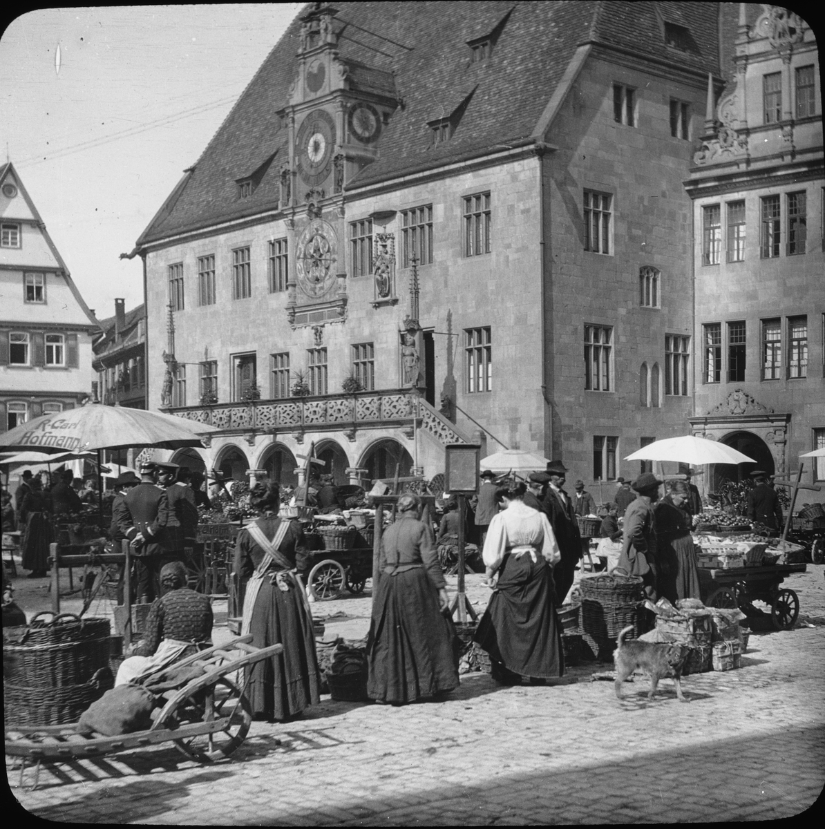 Skioptikonbild med motiv av marknad på torget framför rådhuset.
Bilden har förvarats i kartong märkt: Resan 1908. Heilbronn 7. XXII.
