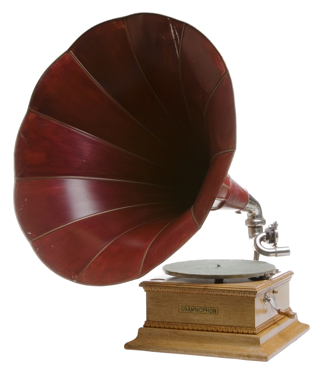 Grammofon, med enkelfjäderverk och jättetratt av lackerad plåt. Höjd: 700 mm med tratt. Lösa delar: Tratt och vev.
