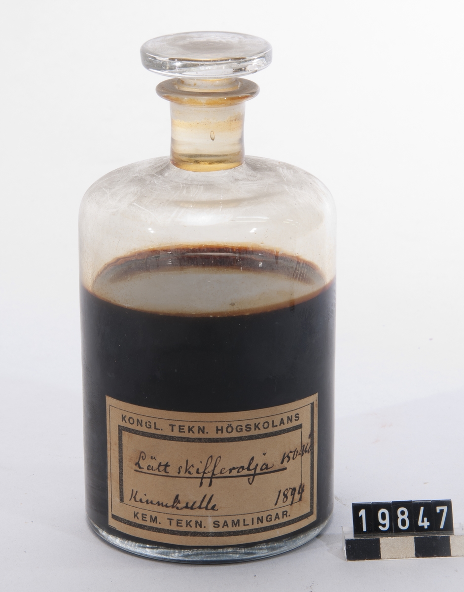 Prov på lätt skifferolja. I flaska av glas med etikett. "Lätt skifferolja. 150-160 grader. Kinnekulle. 1894".