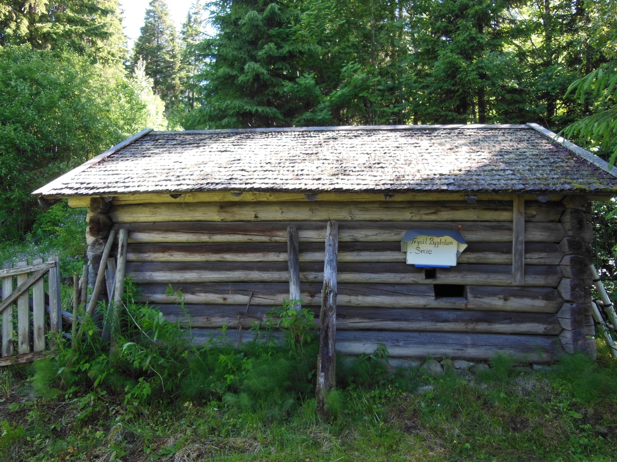 Et laftet tømmerhus med stikketak og dør i gavlveggen. Essa er plassert i hjørnet til høyre for døra.