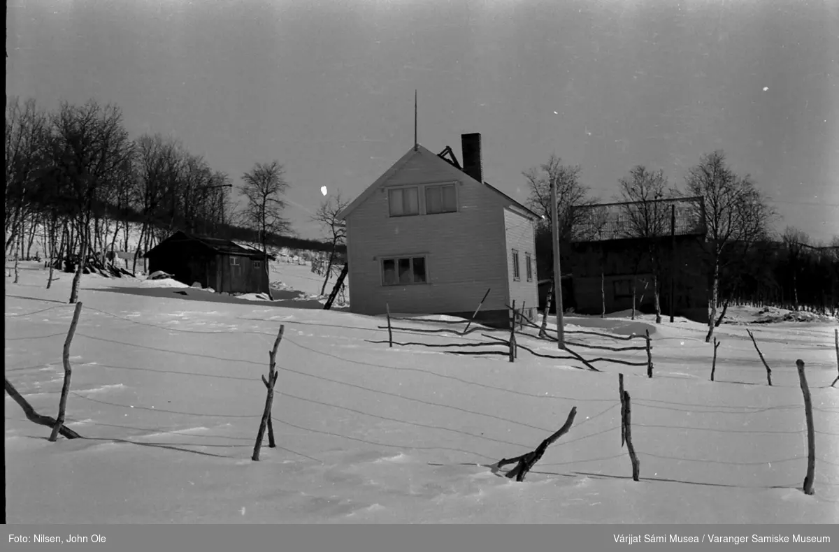 Vinterbilde av huset til Signe og John Ole Nilsen i Bunes. Vi ser vedskjulet, stabburet, huset og fjøset. 1967.