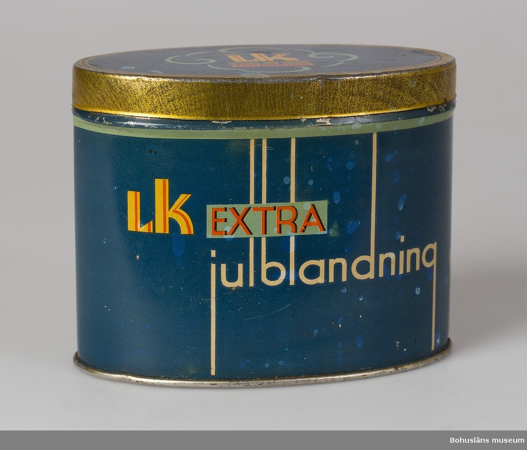 Karamellburk i metallplåt. 
Text: "Aktiebolaget Lidköpings konfektyrindustri. L K extra Julblandning".