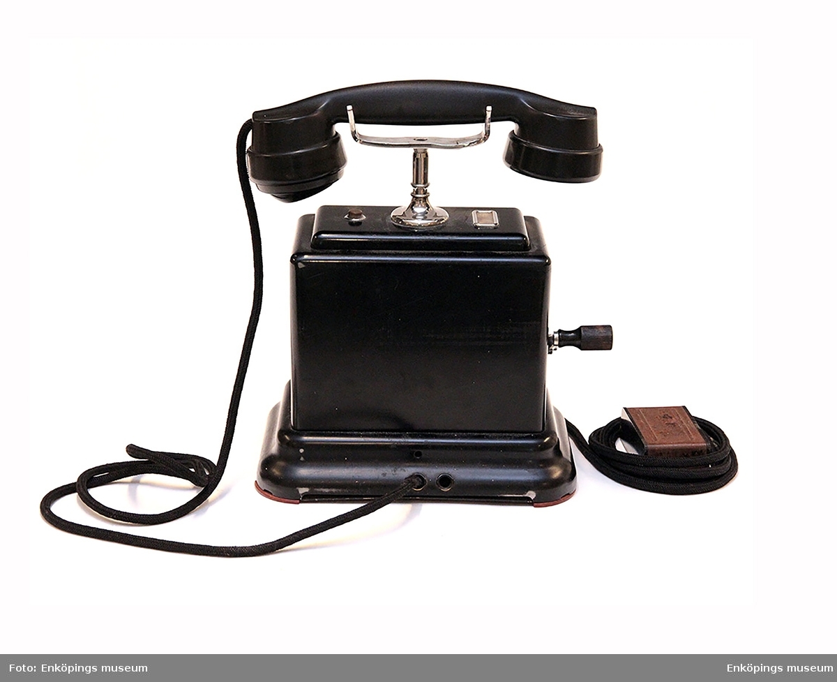 Vevtelefon med vev på ena sidan. På telefonens undersida är den märkt AB100 Schema A   K.T.V.1941.