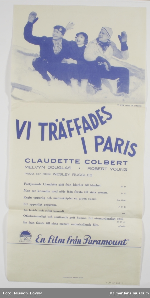 KLM 39208:1. Affisch, av papper. Vit och blå bioaffisch för filmen Vi träffades i Paris, originaltitel I met him in Paris. Under titeln står skådespelarnas namn följt av kritik om filmen.