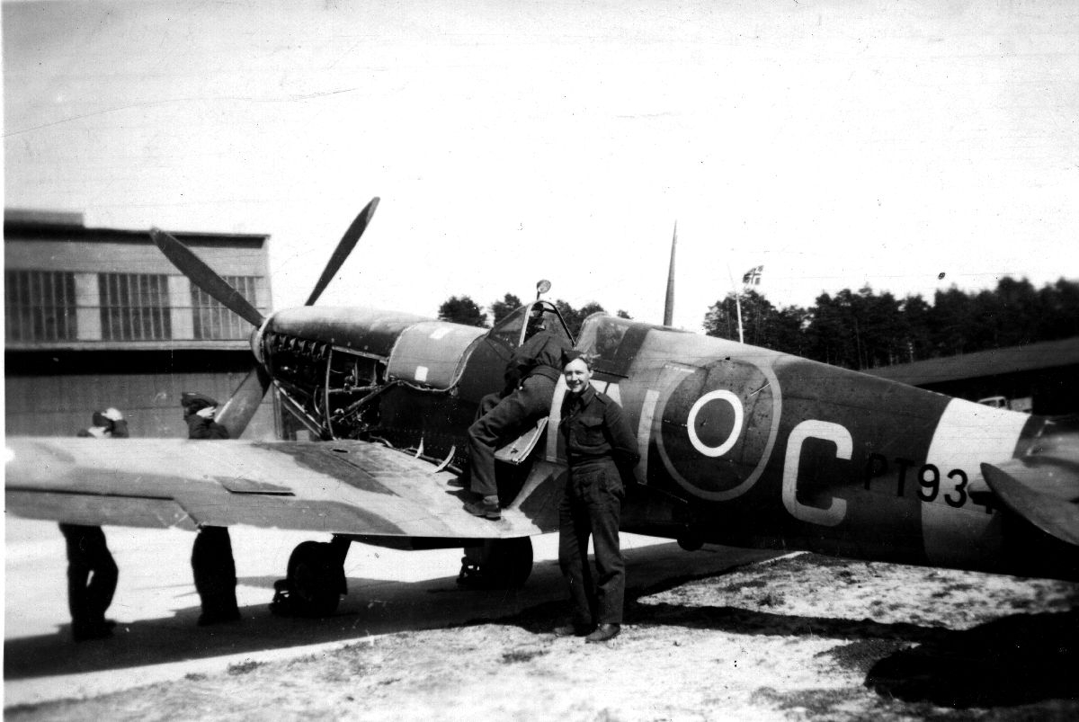 Fire uniformerte personer og et fly av typen Supermarine Spitfire. Det drives ettersyn/vedlikehold på flyet.