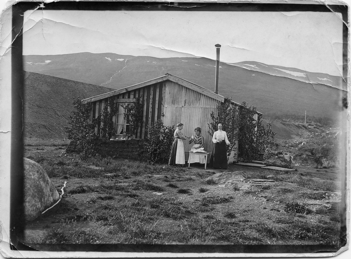 John Bauers Lapplandsresa sommaren 1904. Tre kvinnor utanför Abisko fjällstation där det serveras kaffe.